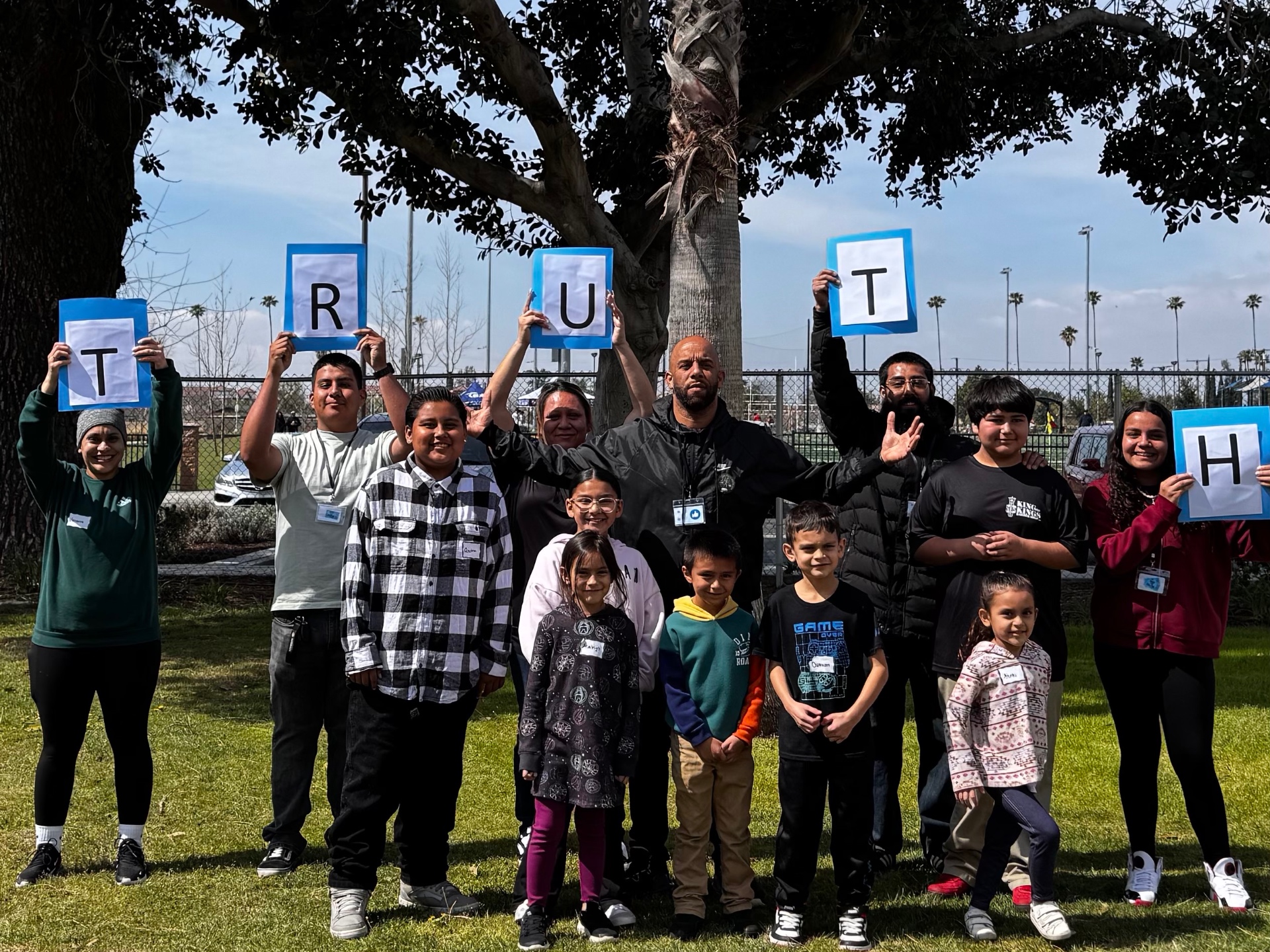 Kids and leaders holding up letters spelling TRUTH at the park
