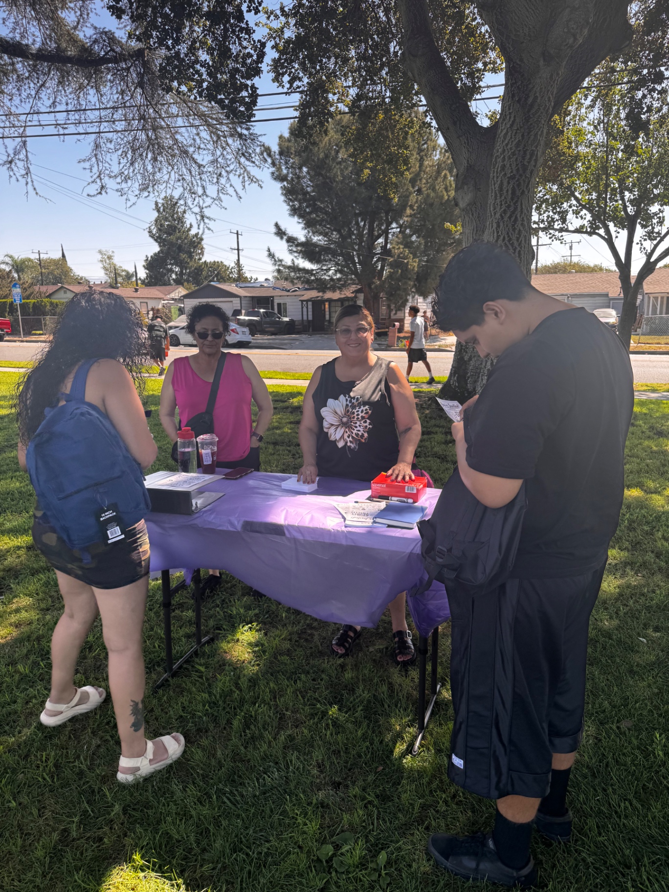 Neighbors signing in at the outreach welcome table in the park