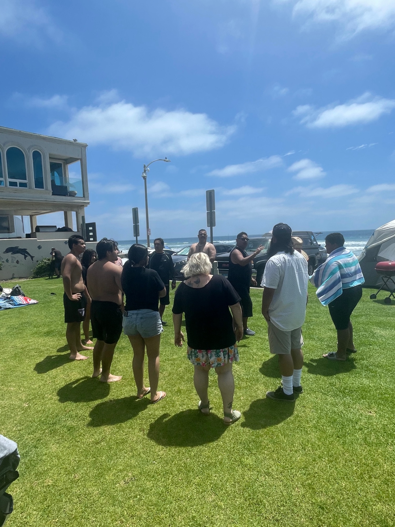 Church members gathered in a circle by the beach before baptisms