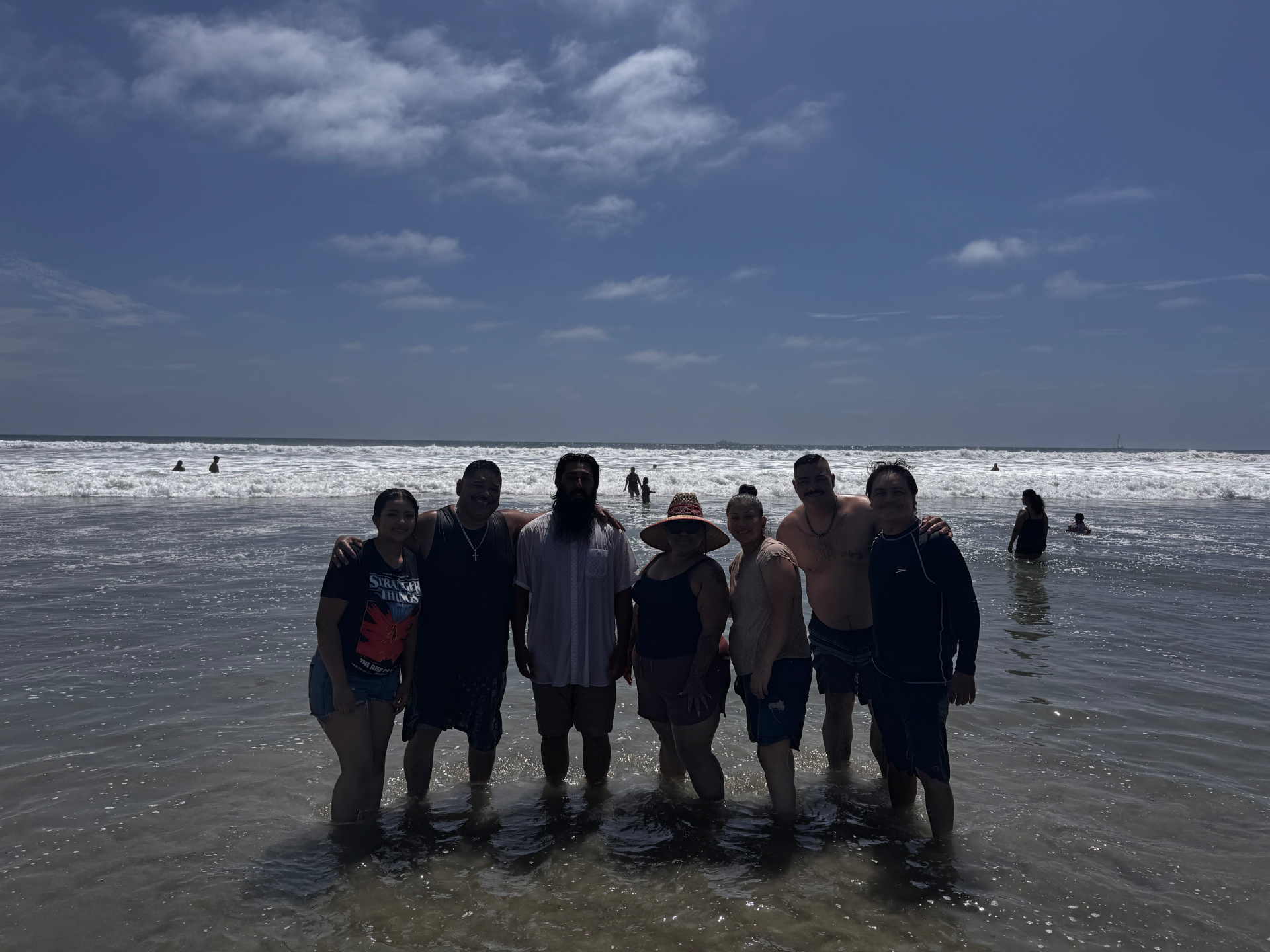 Group photo in the waves celebrating baptism day